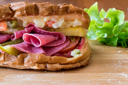 Ayvalik Toast / Salami Sandwich with Russian Salad and pickle on wooden surfaceの写真素材