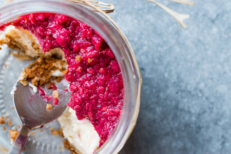 Forest Fruits Cheesecake in Jar with Spoon. / Unfinished Dessert. Organic Food.の写真素材