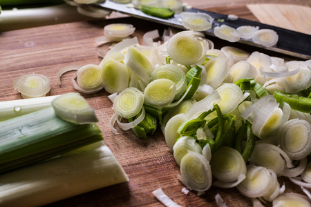 Chopped leek on a wooden surface in the kitchen.の写真素材