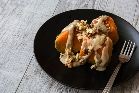 Turkish Pumpkin Dessert with Tahini / Kabak Tatlisi in a black plateの写真素材