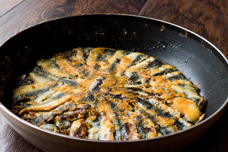 Fresh Fried Sardines in Pan on Wooden Surface. Traditional Food.の写真素材