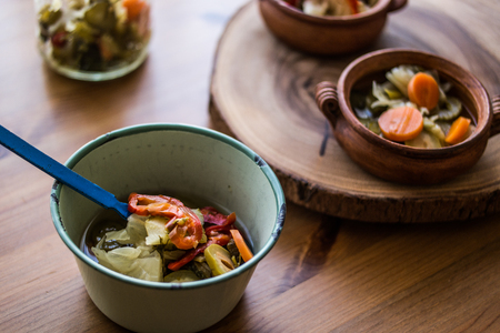 Mix of Turkish Pickles with green tomatoes, red pepper, cucumber and carrot in a bowl.の写真素材