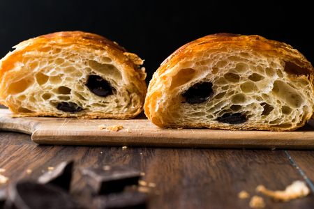 Freshly Baked Chocolate Croissant Half Cut with Knife. Bakery Concept.の写真素材