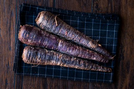 Purple Carrots on Dark Wooden Surface. Organic Food.の写真素材