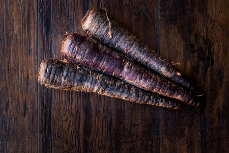 Purple Carrots on Dark Wooden Surface. Organic Food.の写真素材