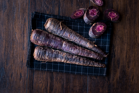 Purple Carrots on Dark Wooden Surface. Organic Food.の写真素材