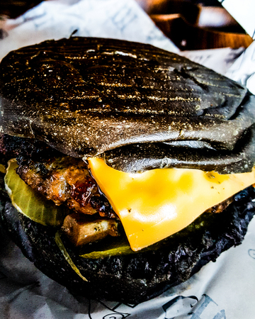 Black Burger with cheddar cheese, mushrooms and pickle. fast foodの写真素材