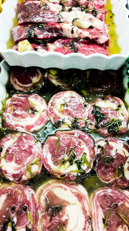 Raw Lamb Meat Roll with greens and olive oil at buthcer. organic foodの写真素材