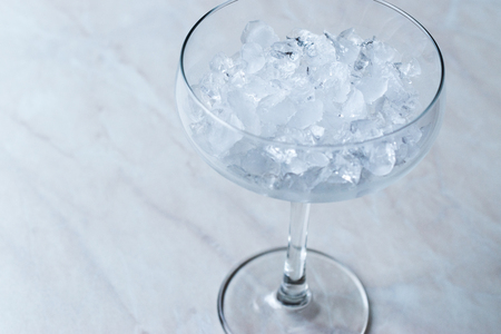 Crushed Ice in Cocktail Glass on Blue Surface. Beverage Concept.の写真素材