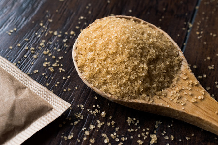 Brown Sugar in Wooden Spoon with Package. Organic Food.の写真素材