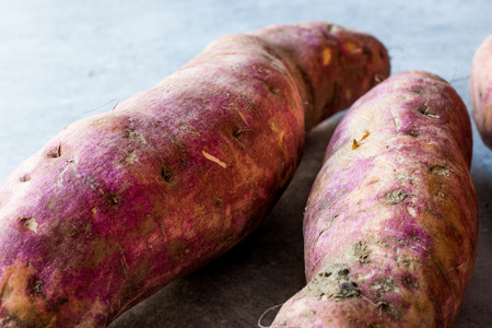 Raw Red Organic Sweet Potatoes on Blue Surface. Organic Food.の写真素材