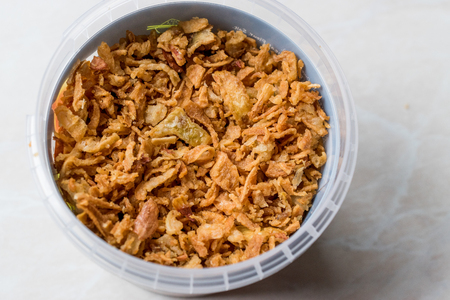 Fried Crispy Onion Flakes in Plastic Package Bowl. Organic Food.の写真素材