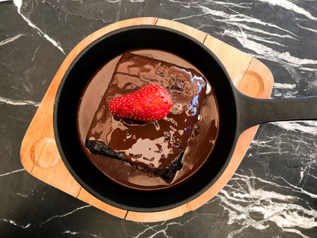 Cream Filled Hot Chocolate Cake Brownie with Strawberry in Pan served at Restaurant.の写真素材