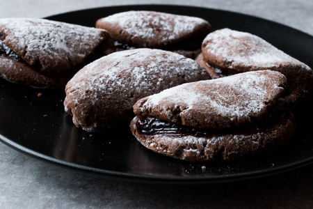 Jelly Filled Chocolate Cookies with Powdered Sugar and Cherry Jam. Dessert Concept.の写真素材