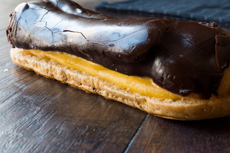 Chocolate Eclairs on Wooden Surface. Dessert Concept.