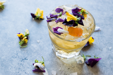 Herbal Iced Tea Cocktail with Edible Flowers and Crushed Ice. Organic Beverage.の写真素材
