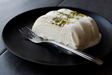 Turkish Maras Vanilla Ice Cream with Pistachio Powder Served Portion in Black Plate. Traditional...