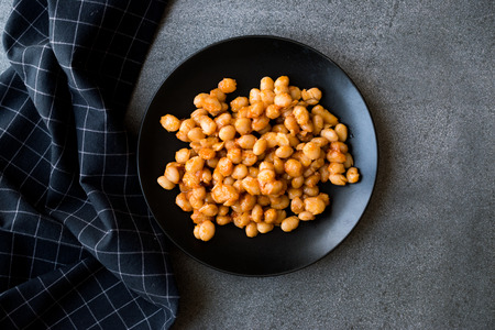 Turkish Cayeli Baked Beans with Butter in Black Plate / Kuru Fasulye. Traditional Organic Food.