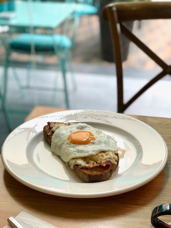Fried Egg with Toast Bread served at Restaurant with White Plate. Organic Food.