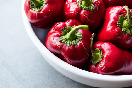 Whole Red Peppers in White Bowl. Close Up View. Organic Food.