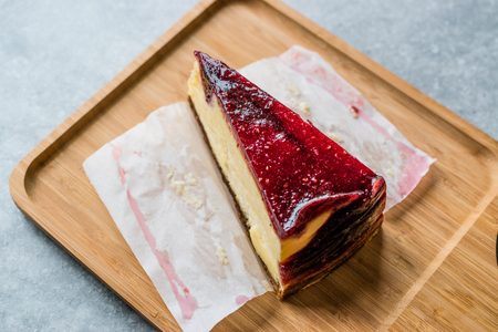 Raspberry Cheesecake Slice on Wooden Board with Paper. Organic Dessert.の写真素材