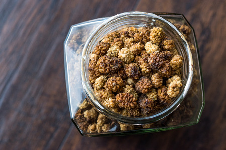 Jar of Dried Mulberries on Dark Wooden Surface. Organic Food.の写真素材