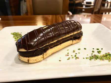 Chocolate Eclairs with Pistachio Powder Served at Restaurant. Organic Dessert.