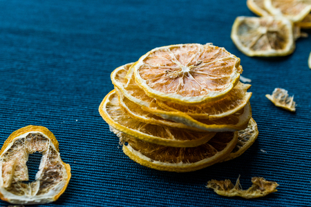 Stack of Dried Lemon Slices on Blue Surface / Dry and Sliced. Organic Food.の写真素材