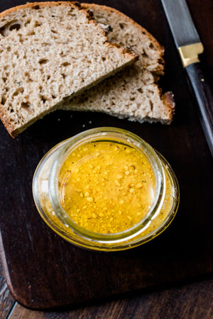 Jar of Peanut Butter with Bread Slices and Knife on Wooden Board for Breakfast.