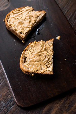 Creamy Peanut Butter with Bread on Wooden Board. Organic Food.