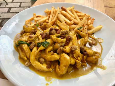 Yellow Spicy Chicken Slices with Turmeric Sauce and Dried Fruits served with Potatoes. Traditional Food.の写真素材