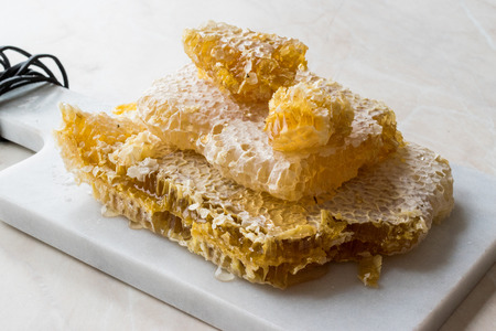 Fresh Honeycomb Slices with Honey on Marble Board. Organic Food.