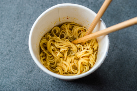 Instant Curry Flavored Ramen Noodles served with Chopsticks. in Plastic Cup. Traditional Fast Food.の写真素材