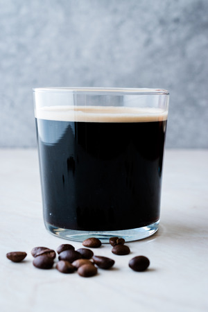 Frothy Cold Brew Nitro Coffee with Beans Ready to Drink. Organic Beverage with Caffeine