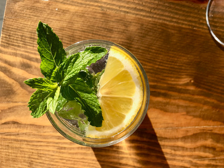 Summer Cocktail Gin Tonic with Fresh Mint Leaves on Wooden Surface Sea View on Holiday at Hotel....
