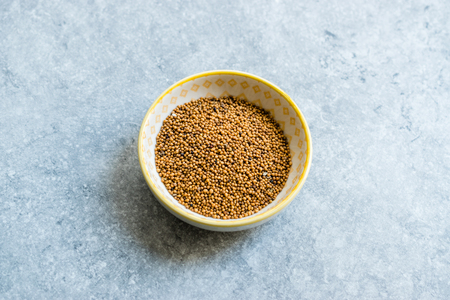 Yellow Mustard Seeds in Small Porcelain Bowl. Organic Product.の写真素材