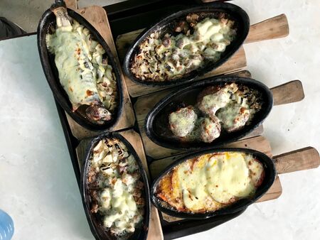 Turkish Seafood Trout Alabalik Fish with Bechamel Kashar Sauce,  Meatball Kofte / Kofta, Cubed Lamb Meat Cubes in Casserole / Guvec. Organic Food.の写真素材