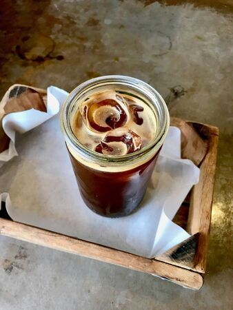 Cold Ice Coffee Americano in Jar with Wooden Tray at Cafe Shop. Summer Beverage.