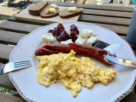 Bratwurst Sausage with Scrambled Eggs, Cheese and Quince Jam / Marmalade for Breakfast.の写真素材