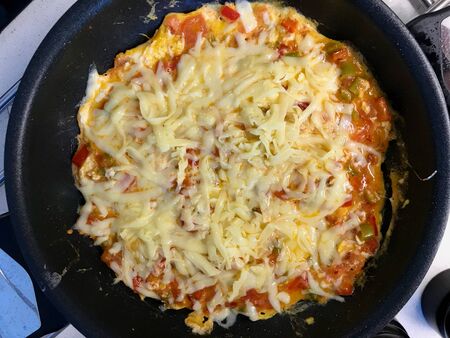 Turkish Breakfast Food Menemen in Pan with Melted Cheese Kashar. Traditional Organic Food.
