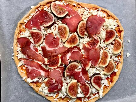 Raw Whole Fig Pizza with Pastrami and Prosciutto. Fast Food.