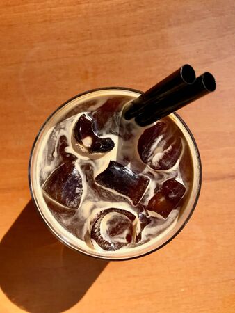 Cold Brew Coffee Americano with Ice at Cafe Shop served on Wooden Table. Organic Beverage.