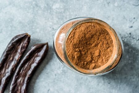 Carob Powder and Pods Ready to Use in Jar. Organic Food.の写真素材