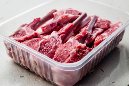 Raw Bloody Lamb Chops Meat in Plastic Package / Box or Container. Organic Food.