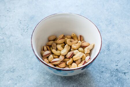 Cashew and Siirt Pistachios in Ceramic Bowl. Healthy Organic Snacks Ready to Eat.の写真素材