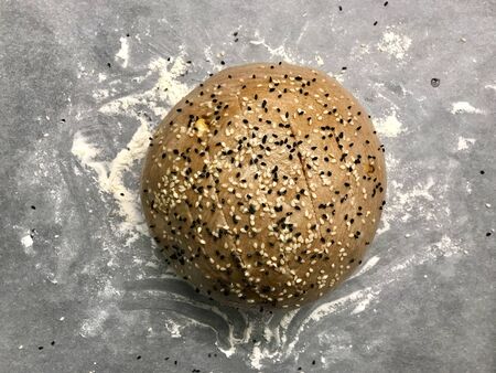 Karakilcik Wheat Raw Bread with Black Cumin Seeds on Baking Paper with Flour. Organic Food.