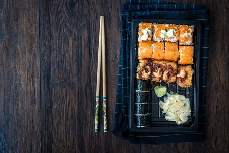 Sushi Set in Plastic Container Box / Package. California Roll, New York Roll, Boom Roll, Ginger, Wasabi and Soy Sauce. Traditional Food.の写真素材
