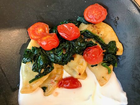 Turkish Ravioli Dumplings Piruhi / Manti with Spinach, Yogurt and Cherry Tomatoes. Traditional...