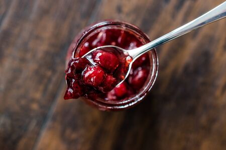 Cranberry Jam in Jar with Spoon / Cranberries Marmalade served with Bread Slices for Breakfast.