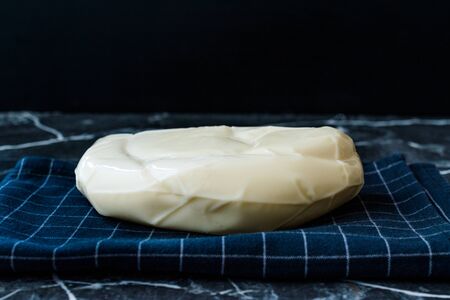 Turkish Cheese Abaza Peyniri on Black Tablecloth. Traditional Organic Food.